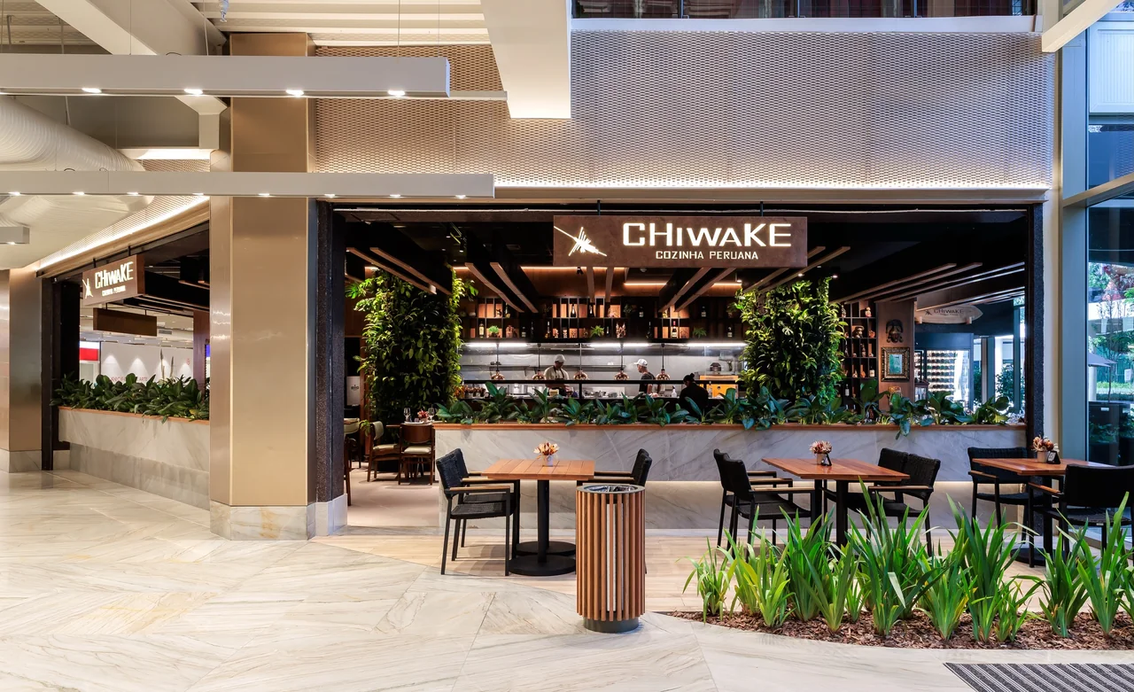 Restaurante Chiwake com vegetação junto às mesas e à entrada.